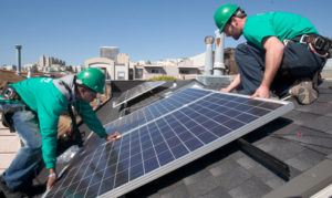 Micah Fromkin, right, crew leader for Solar City solar panel installers and Christian Lee, a junior installer, carefully place a solar panel onto the roof of a residential building in San Francisco, Wednesday, March 11, 2009. (D. Ross Cameron/Staff Archives)