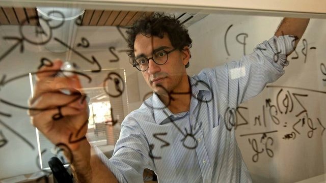Simon Dedeo writing on board