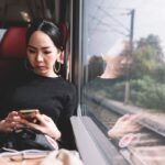 asian-woman-using-mobile-phone-on-the-train-while-traveling_t20_P3PJYR