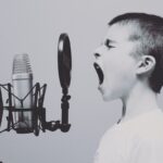 Little boy yelling into microphone