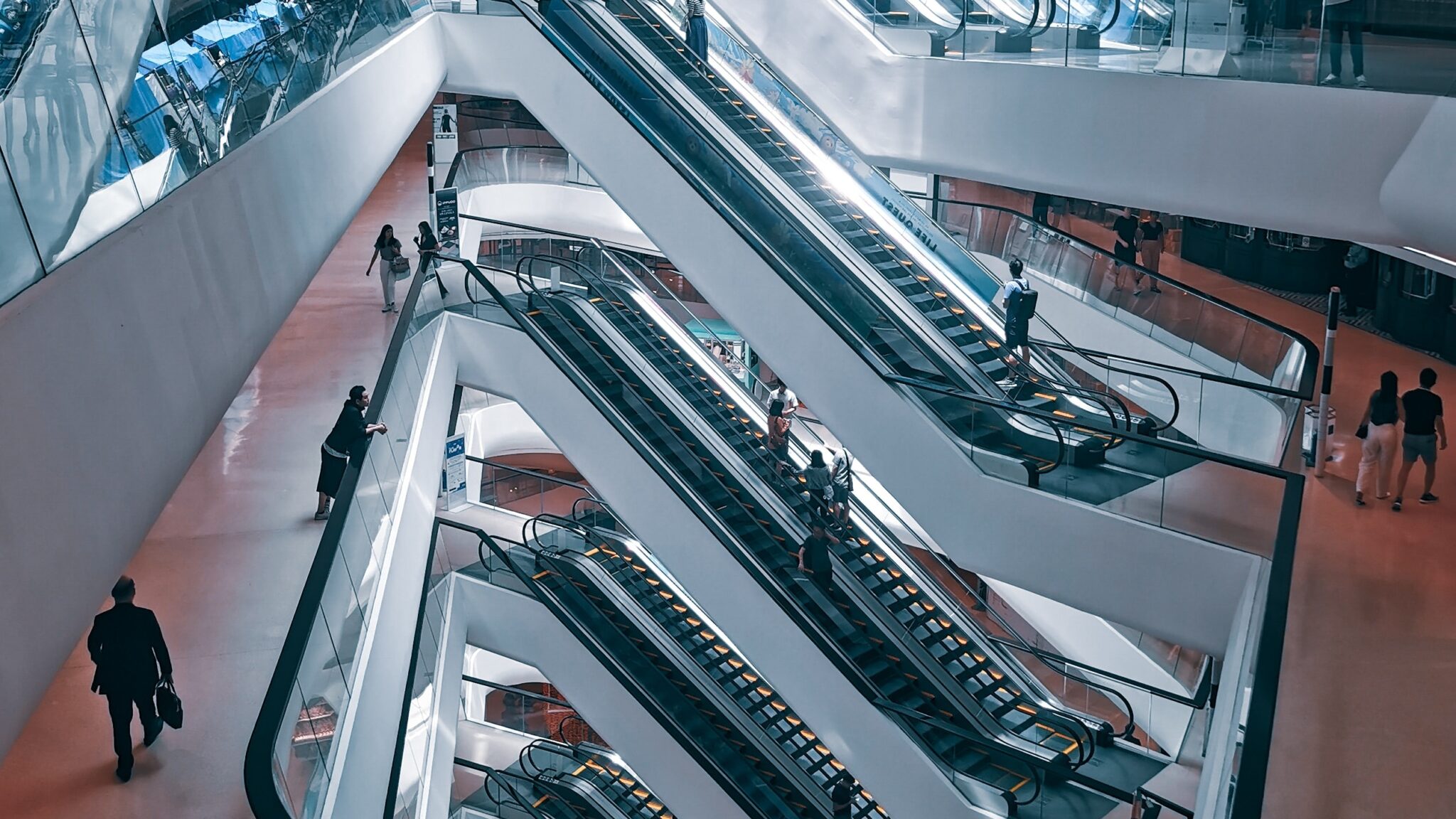 Decorative: a large space with intertwining escalators and people scattered throughout